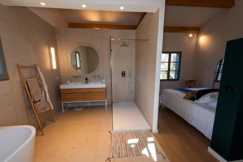 a bathroom with a shower and a sink and a bed at Villa CAMILLE in Ersa