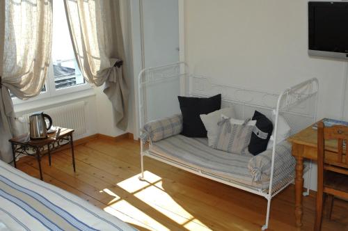 a room with a white bed with pillows on it at Auberge de la Gare in Grandvaux