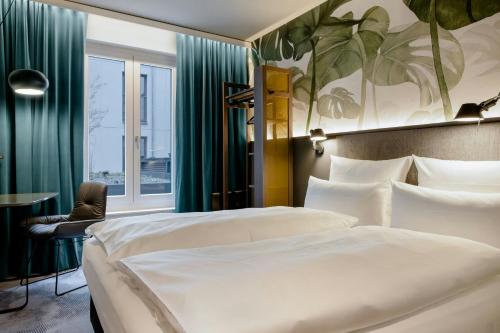 a hotel room with a bed and a window at Motel One München-Hauptbahnhof in Munich