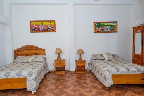 a bedroom with two beds and two night stands at Preloune Residences SA in Cap-Haïtien