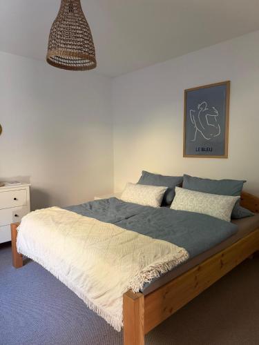 a bedroom with a bed and a pendant light at Casa Tilly - Ferienhaus am Wald in Zwingenberg