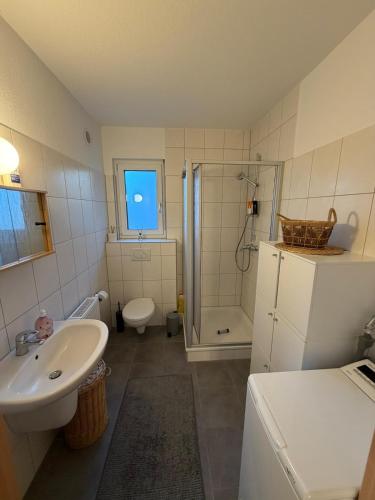 a bathroom with a sink and a shower and a toilet at Casa Tilly - Ferienhaus am Wald in Zwingenberg
