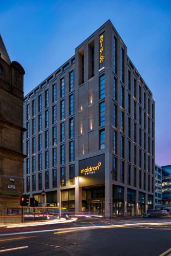 a large building with a sign on the side of it at Maldron Hotel Glasgow City in Glasgow