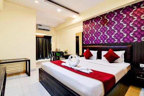 a bedroom with a large bed with a red blanket at Hotel Eco Park By Carlton Suites in kolkata