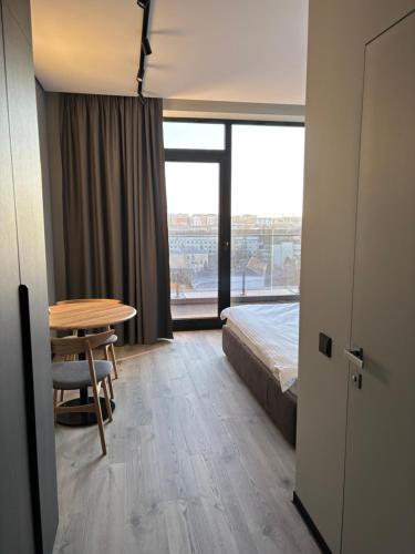 a room with a bed and a table and a bed and a window at Bavaro apartments 3 in Ivano-Frankivsk