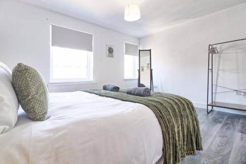 a white bedroom with a large bed with a blanket on it at Colchester 4BR Home, Sleeps 8, Fast WiFi, Perfect for Contractors in Hythe