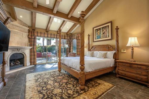 a bedroom with a canopy bed and a fireplace at Villa Merion at PGA West | Grand Tuscan Estate in La Quinta