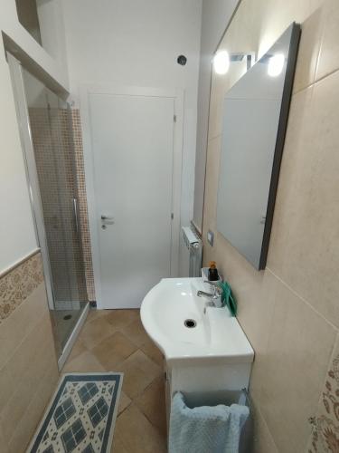 a white bathroom with a sink and a mirror at Mira Beach Casa Vacanze in Praia a Mare