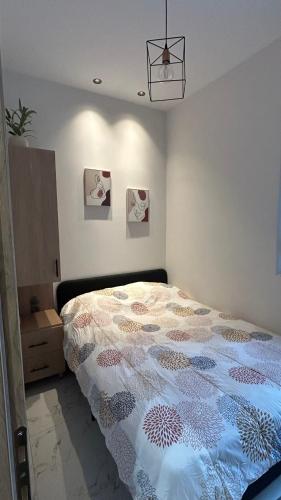 a bedroom with a bed with a quilt on it at The Little House Lamia - Fresh Central Apartment in Lamía