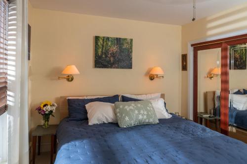 a bedroom with a blue bed and two lamps at Forest City Oasis and Spa in South Portland