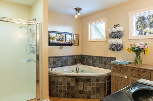 a bathroom with a tub and a shower and a sink at Forest City Oasis and Spa in South Portland