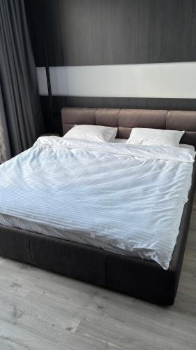 a large bed with white sheets and pillows at Bavaro apartments 3 in Ivano-Frankivsk