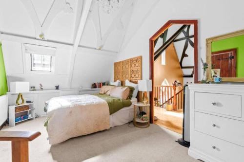 a bedroom with a bed and a large mirror at Church conversion, Private garden, Parking in Cuckfield