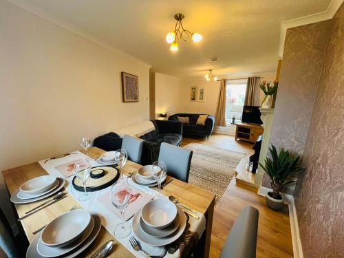 a living room with a table and a dining room at Inas Place in Caol