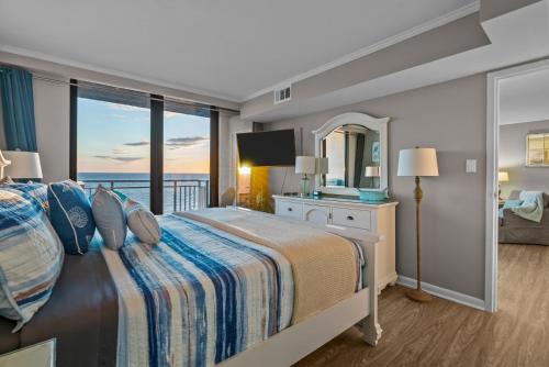 a bedroom with a bed with a view of the ocean at Beachfront Condo/ Pool/ Surfing/ Fishing / EW 1202 in Virginia Beach