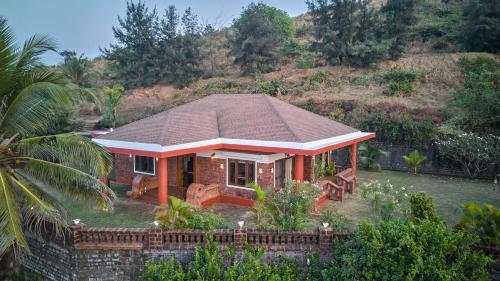 a small house with a roof on top of a yard at SaffronStays The Devrai by the Sea in Bhogwe