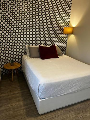 a bedroom with a white bed with a patterned wall at LAZARO E - In the heart of San Pedro in Monterrey