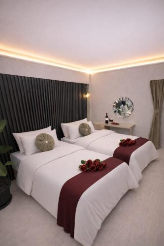 zwei Betten in einem Hotelzimmer mit Blumen darauf in der Unterkunft Zebra Hotel Buca in Izmir