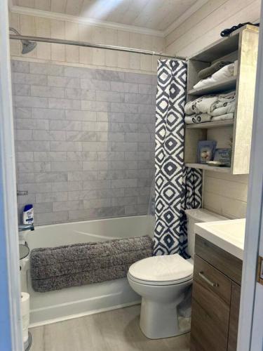 a small bathroom with a toilet and a bath tub at Captain Cottage in Bowen Island
