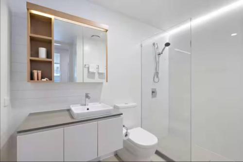 a white bathroom with a sink and a toilet at Balcony Apt with 1 Bedroom in Belconnen