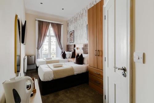 a bedroom with two beds and a window at Mina Hotel by PLI in London