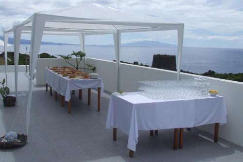 two tables with white table cloths on a roof at Cantinho das Buganvilias AT**** in Queimada