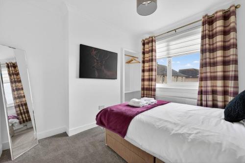 a bedroom with a bed and a large window at Troon Golf by the Sea in Troon