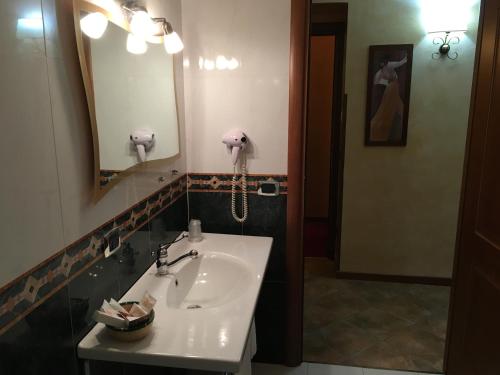 a bathroom with a sink and a phone on the wall at Hotel Al Ritrovo in Piazza Armerina