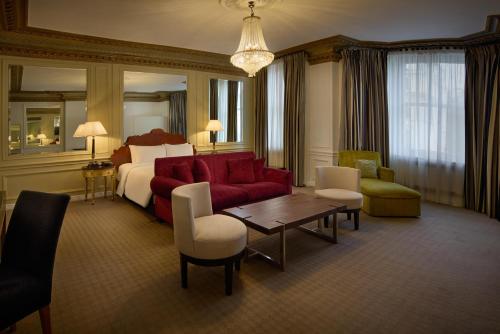 ein Hotelzimmer mit einem Bett und einem roten Sofa in der Unterkunft Radisson Blu Hotel, London South Kensington in London
