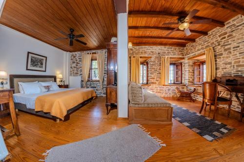 a bedroom with a bed and a brick wall at xenonas ton xromaton - Guest house of colors in Lafkos