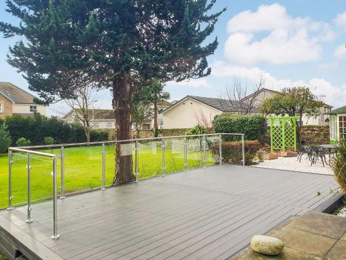 a wooden deck with a tree in a yard at Springvale in Cardross