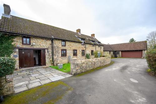 a stone house with a driveway in front of it at Laurel House - Pool, Sauna & Gardens - Sleeps up to 12 people by STAE-Homes in Magor