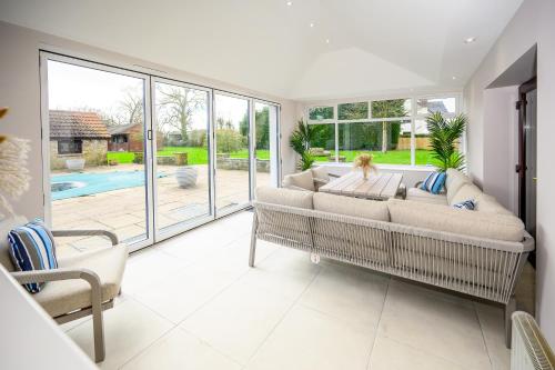 a living room with a couch and a large window at Laurel House - Pool, Sauna & Gardens - Sleeps up to 12 people by STAE-Homes in Magor