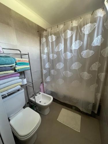 a bathroom with a toilet and a shower curtain at Depto Berazategui Centro in Berazategui