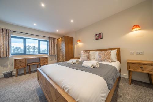 a bedroom with a large bed and a desk at Elder howe in Penrith