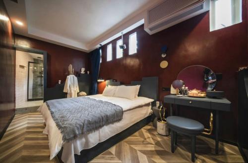 a bedroom with a bed and a table and a stool at My loft ChengDu in Chengdu