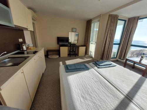 a room with a bed and a kitchen with a view at Berlin Golden Beach Studio in Varna City