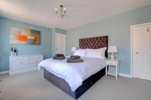 a bedroom with a large bed with two towels on it at 5 Bed in Southwold oc-hjames in Southwold