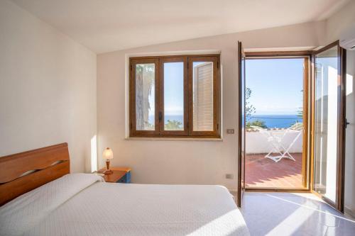 a bedroom with a bed and a view of the ocean at CAPOVILLAS - Villa Laura with private pool in Vibo Valentia