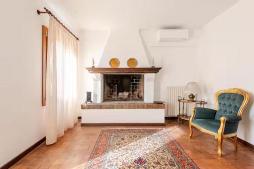 a living room with a fireplace and a green chair at "Venetian Elegance Villa" - near Venice historic center in Mira