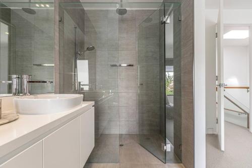 a bathroom with a sink and a glass shower at The Pool Pavilion - Where City meets Beach in Melbourne