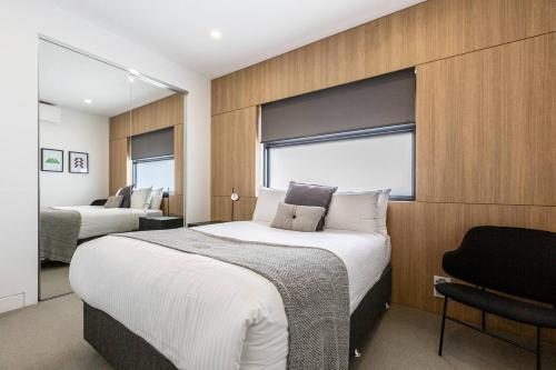 a bedroom with two beds and a window at The Pool Pavilion - Where City meets Beach in Melbourne