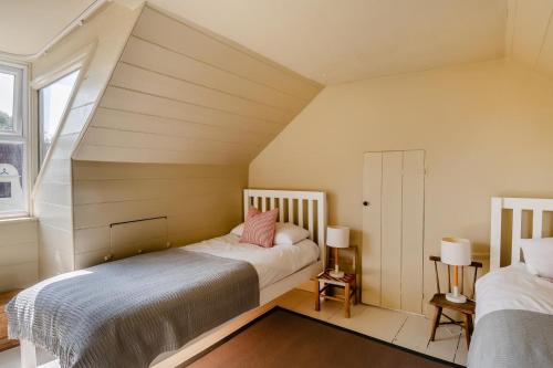 a attic bedroom with two beds and a window at 4 Bed in Walberswick oc-hwfern in Walberswick