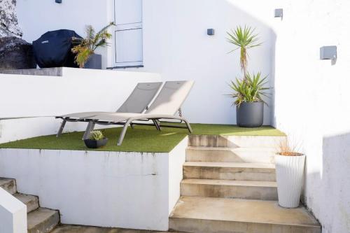 a chair sitting on the side of a building with stairs at GuestReady - Sea Escape Azores in Lagoa