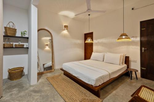a bedroom with a bed and a mirror at La Cove in Matara