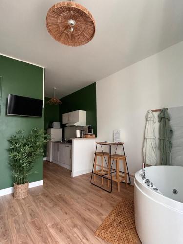 a bathroom with a tub and a table and a television at Dodo Créole in Laval