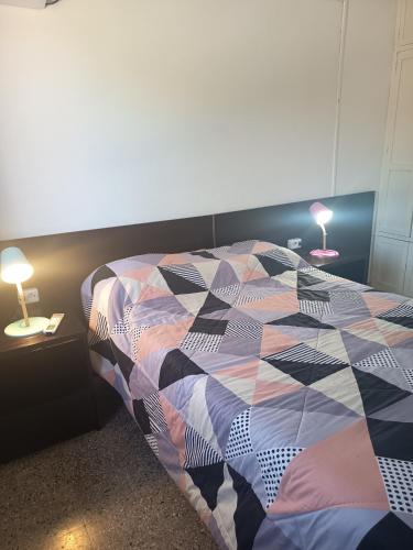 a bedroom with a bed and two tables with lamps at Apartamento duplex único en Carmelo in Carmelo