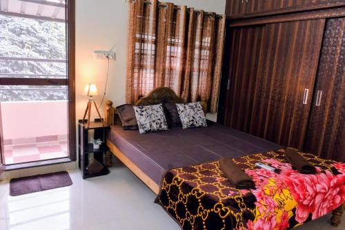 a bedroom with a bed and a large window at Aura attic residency in Bangalore