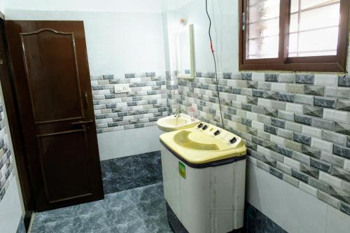 a bathroom with a sink and a mirror at Aura attic residency in Bangalore