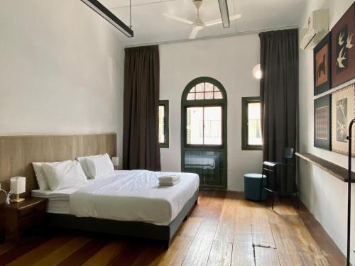 a bedroom with a large bed and a window at Aceh Suites by Aayu - 1 min walk to Armenian St in George Town